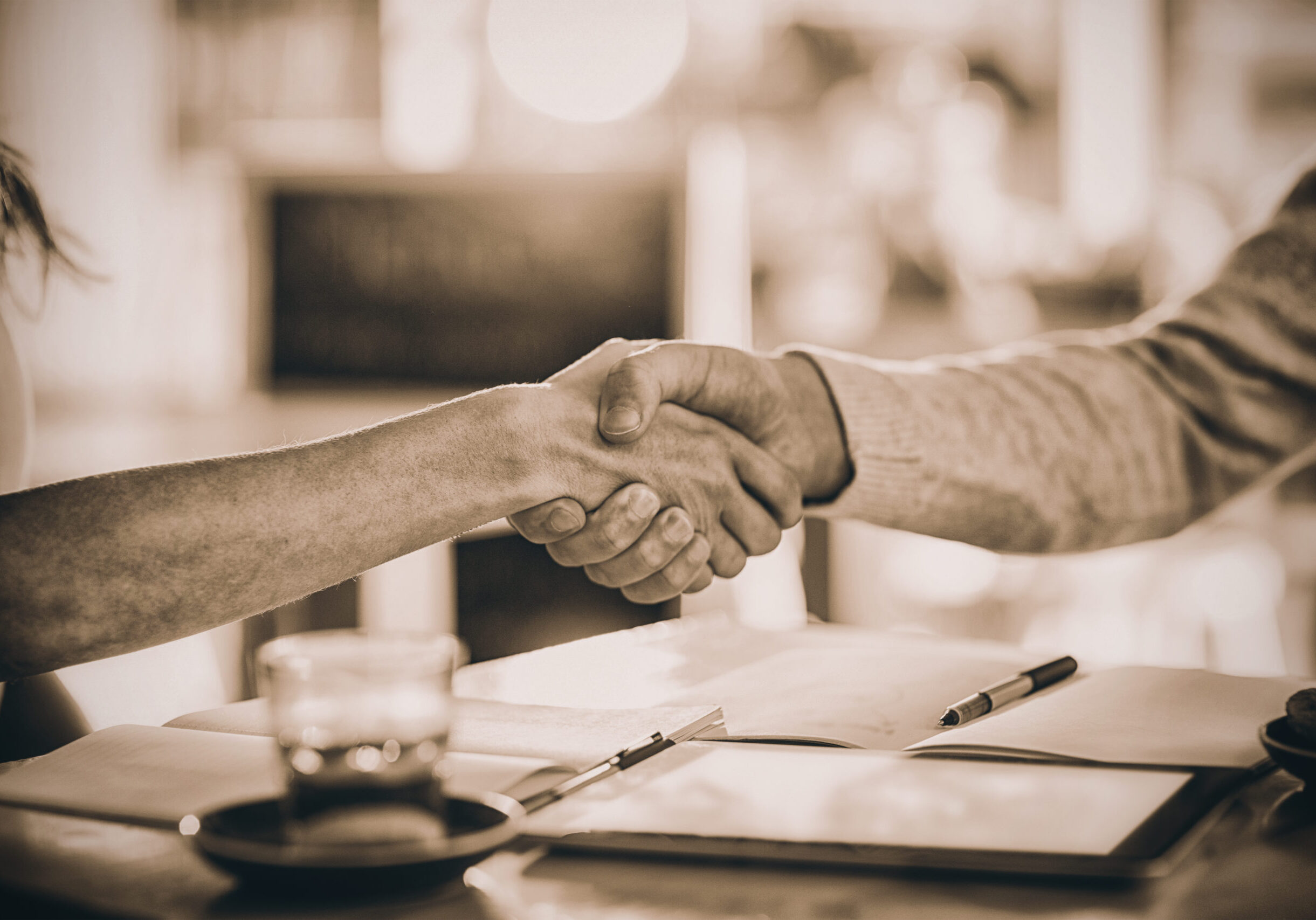 friends-shaking-hands-in-cafe